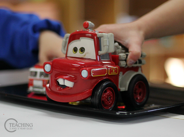 toddler painting with firetrucks