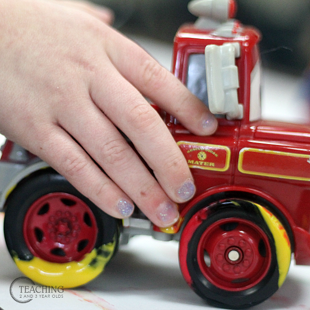 toddler painting with firetrucks